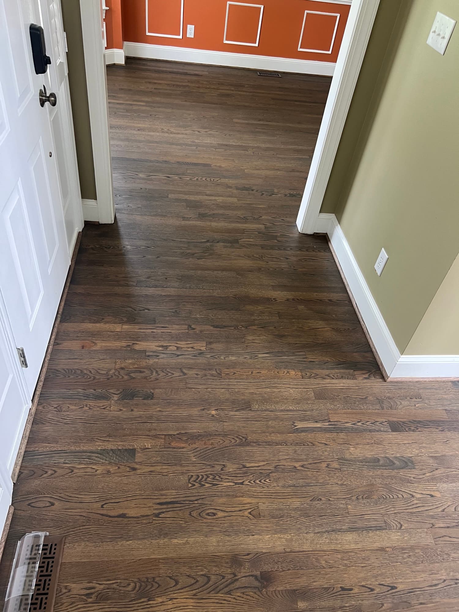 Finished white oak floors in entry and hallway of Ole Mill Stream Clayton NC home, looking through doorways into refinished rooms with custom hardwax oil blend