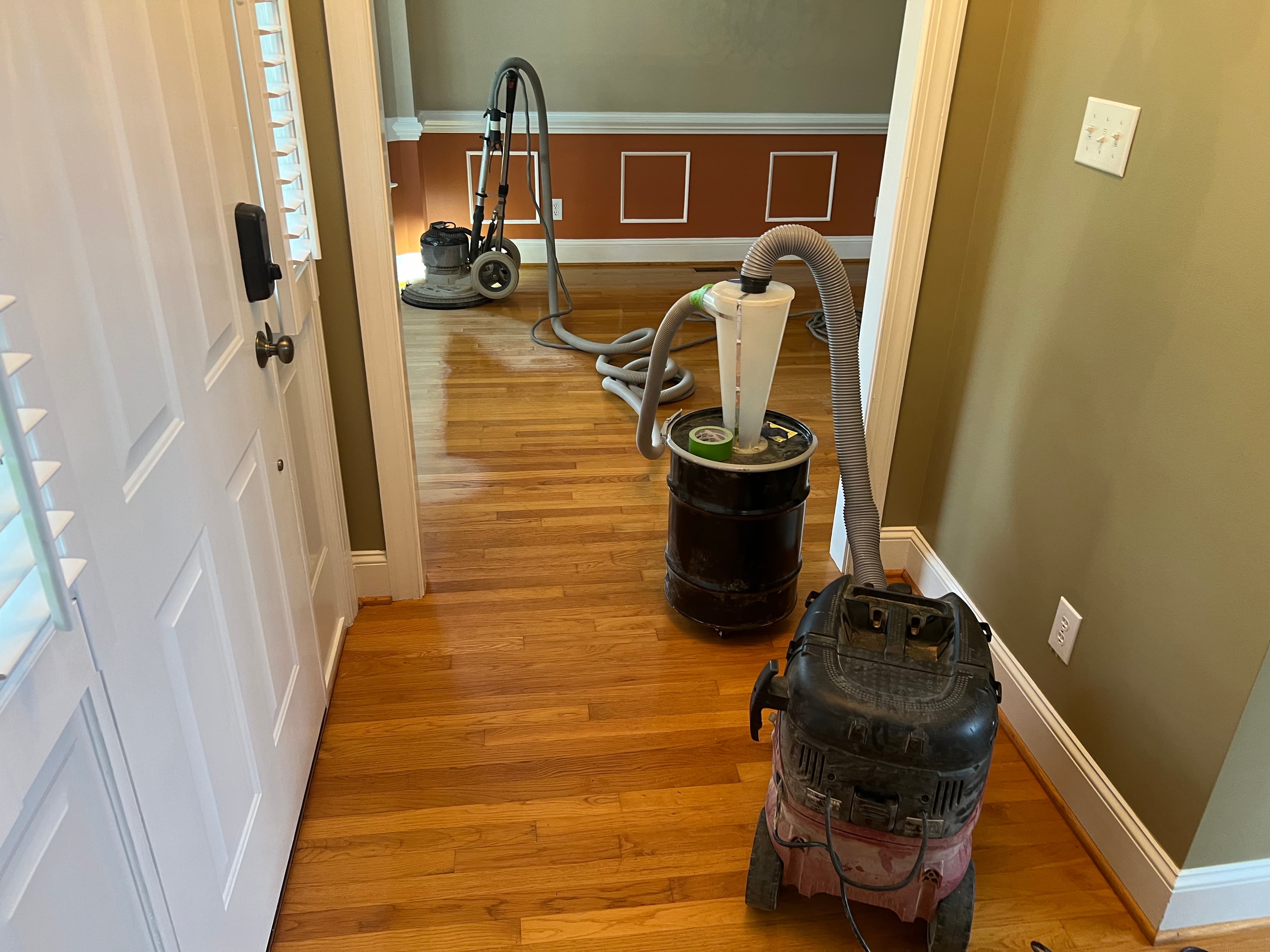 Bona PowerDrive planetary sander in use during white oak refinishing in Ole Mill Stream Clayton NC, looking through doorway with dust separator in hallway