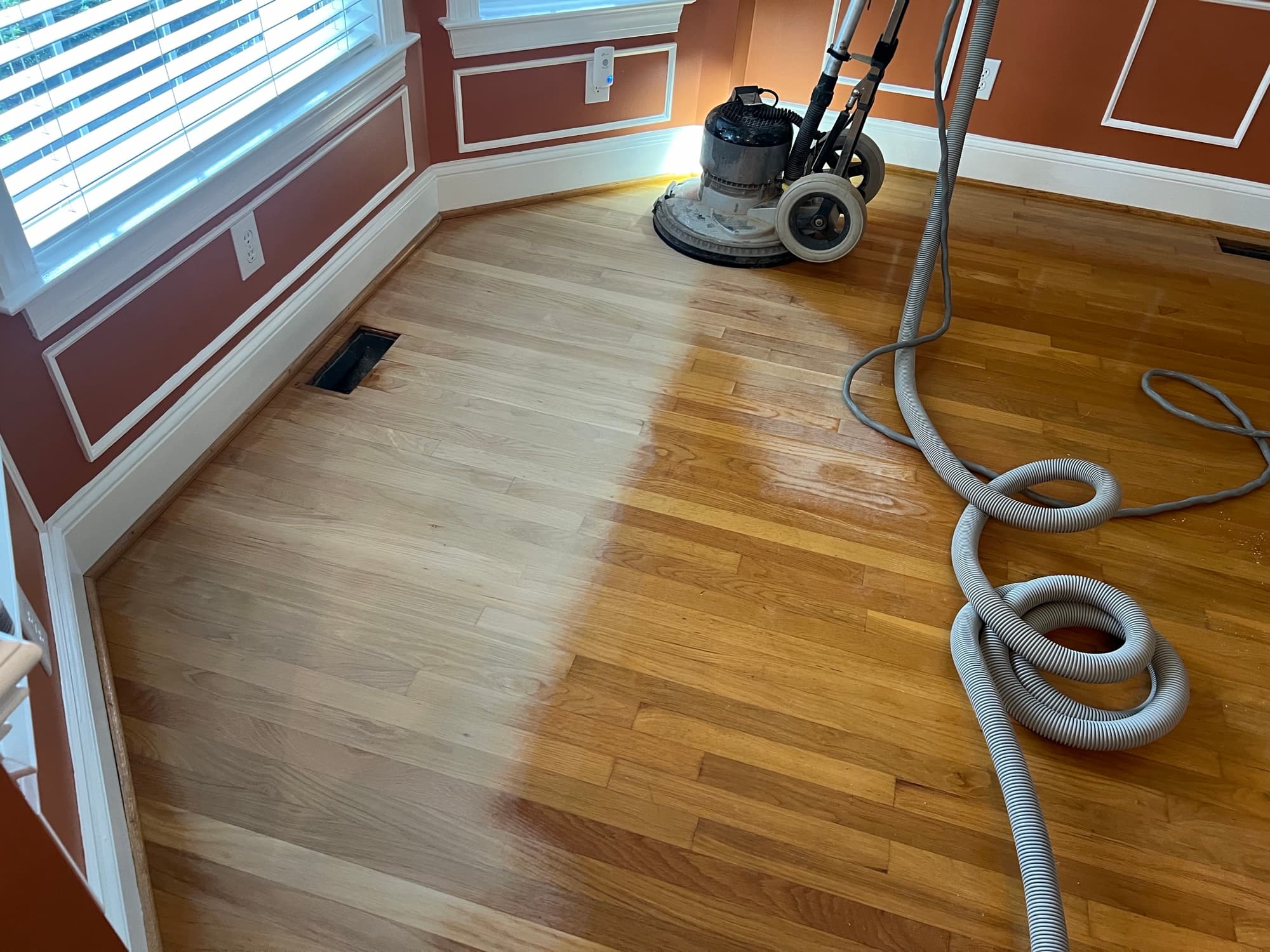 Bona PowerDrive sanding white oak floors in Ole Mill Stream Clayton NC, showing contrast between sanded pale wood left and old amber finish right