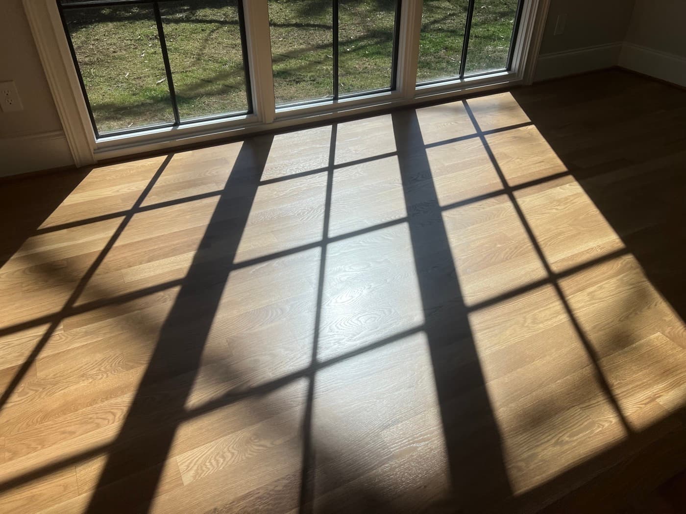 Finished custom DuraSeal Weathered Oak blend on white oak with window grid light pattern in Hayes Barton Raleigh NC