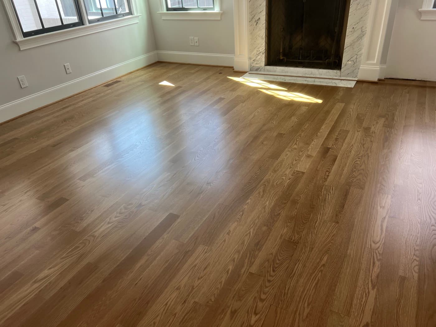 Finished white oak floors with custom Weathered Oak blend and Bona Traffic HD in morning light at marble fireplace in Hayes Barton Raleigh NC