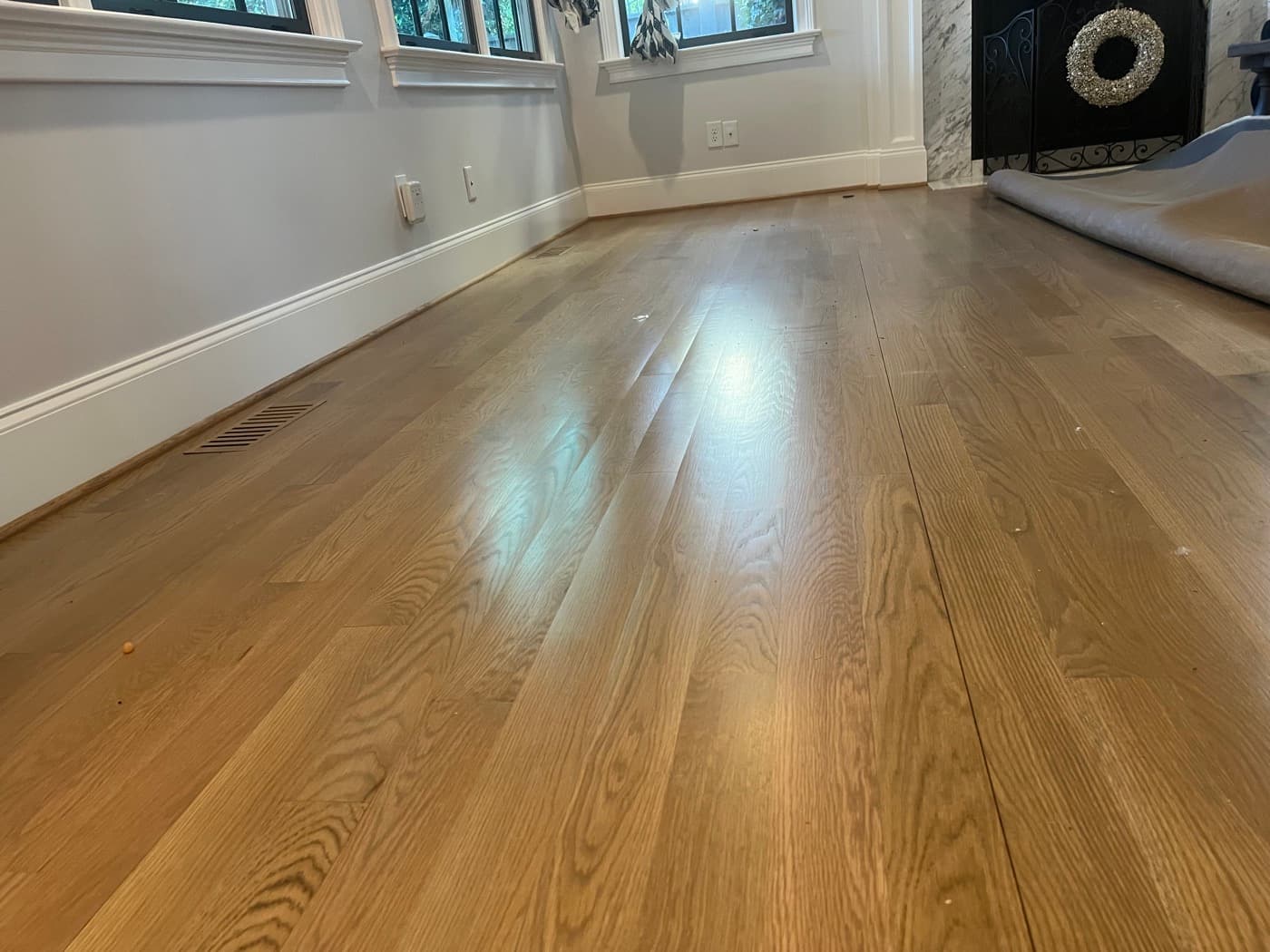 Crowned white oak boards in family room showing raised center of boards visible under room lighting in Hayes Barton Raleigh NC