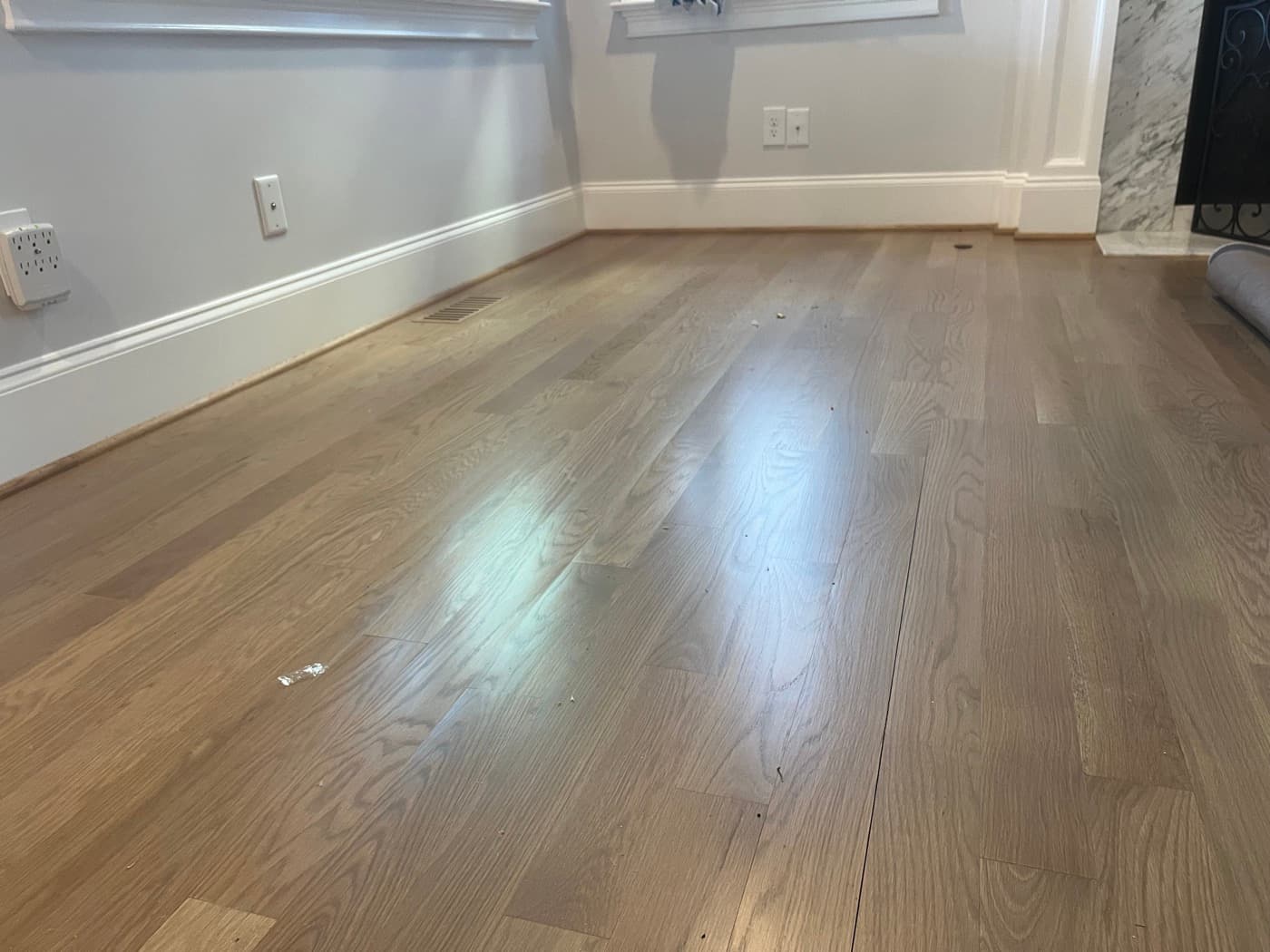 Second angle of crowned white oak boards in family room showing board center ridging pattern across the floor in Raleigh NC