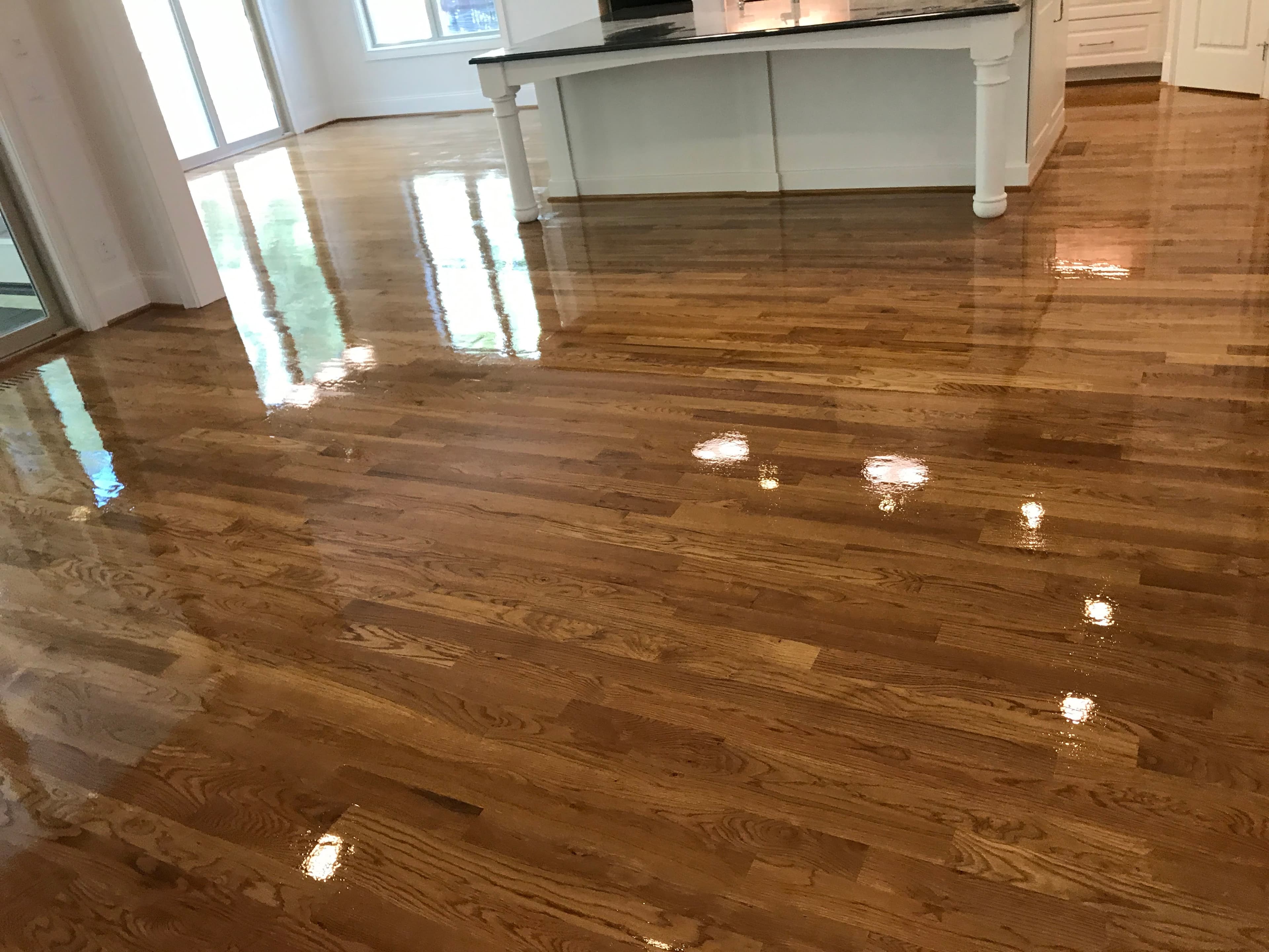 Red oak hardwood floor screen and recoat with Bona Traffic HD, fresh finish application in open-plan kitchen