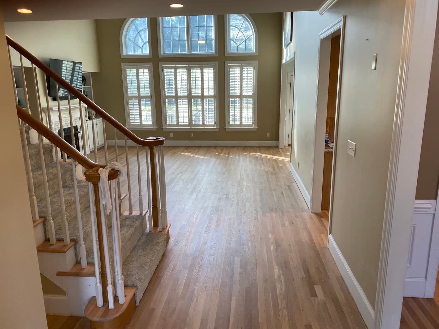 Two-story foyer in Glen Laurel, Clayton NC with natural hardwax oil red oak flooring and new white baseboard sitting directly on the floor with no shoe molding