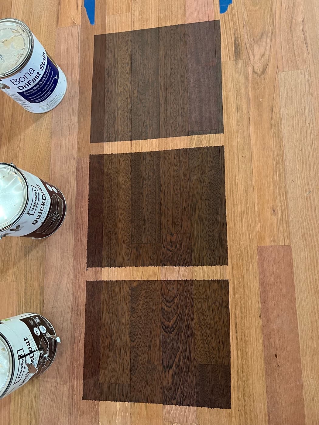 Three stain samples on Brazilian cherry hardwood showing how Jacobean, Ebony, and Bona Driftwood reduce the natural red tones
