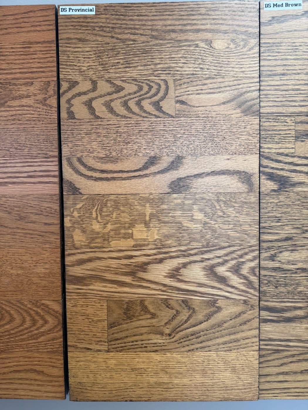DuraSeal Special Walnut and DuraSeal Provincial side by side on showroom wall boards: top half red oak, bottom half white oak