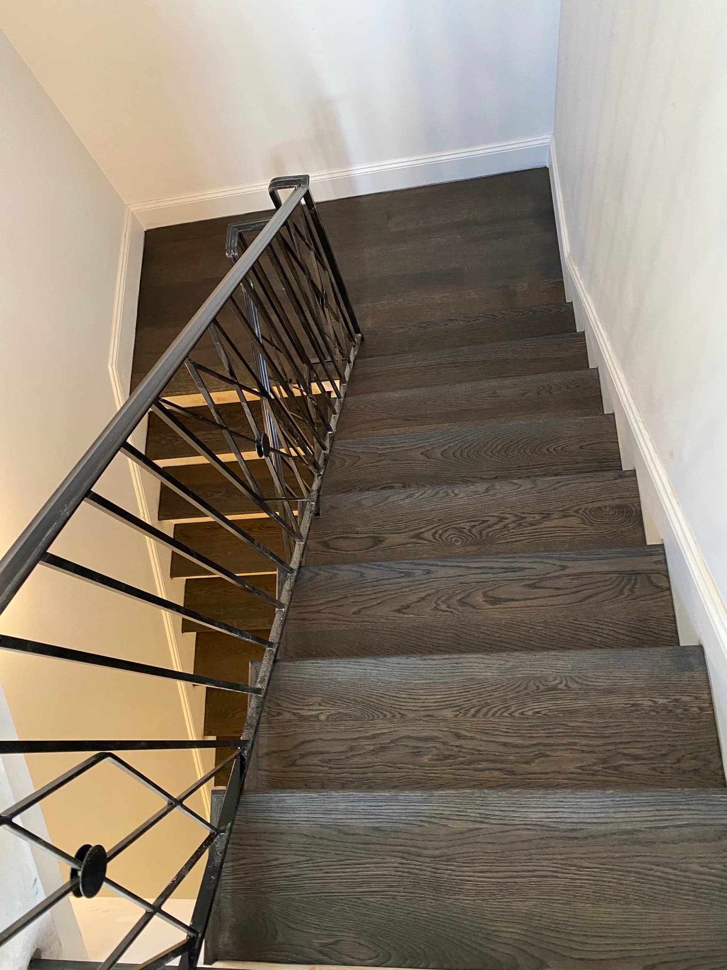 Dark stained oak staircase remodel with iron railing by 12th And Oak Floor Co. Clayton NC
