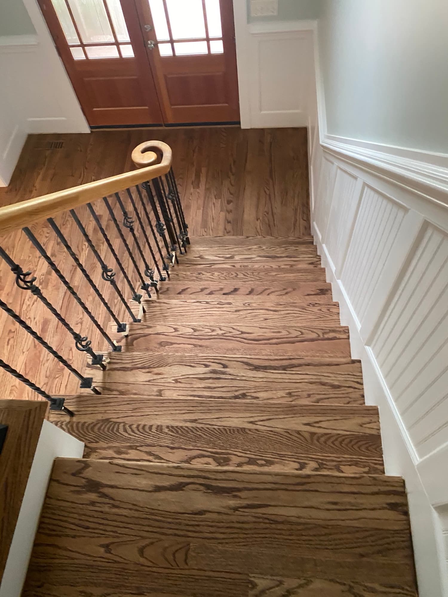 Completed white oak staircase remodel with iron balusters in Cary NC